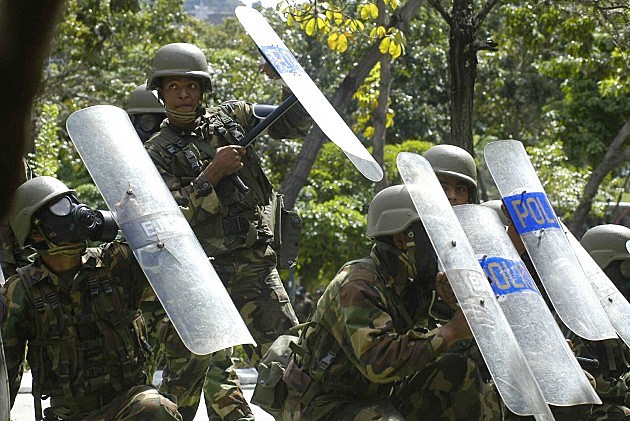 Venezuelan Soldiers Shield Themselves From Gunshots